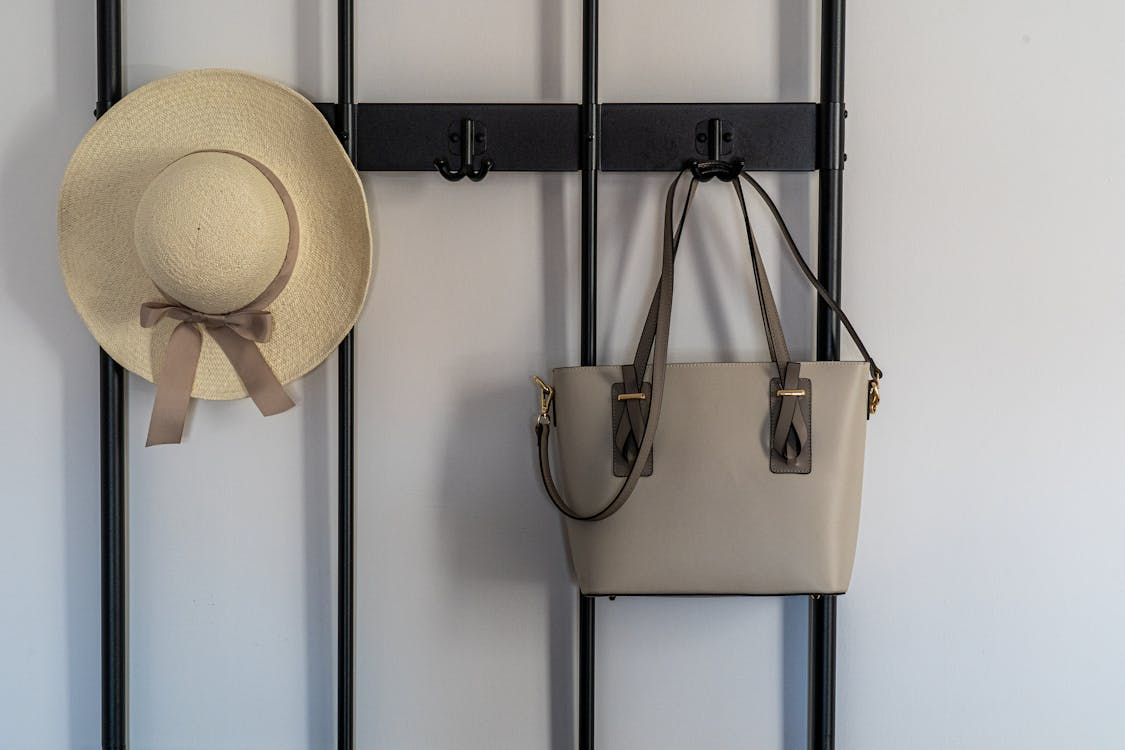 Minimal entryway with bag and hat hung neatly showing small organization habits