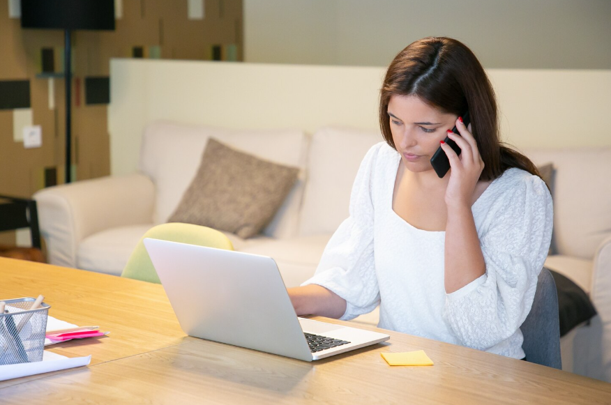 Woman calling provider while reviewing laptop to negotiate your internet bill