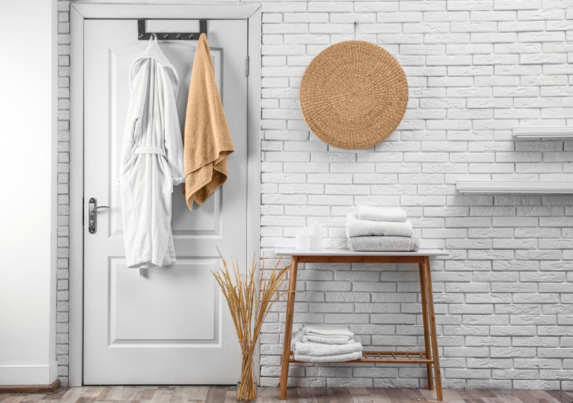 Entryway organized using the one-touch rule for clutter with robe and towel hung